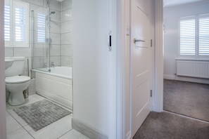 Un baño con inodoro, bañera y ducha.