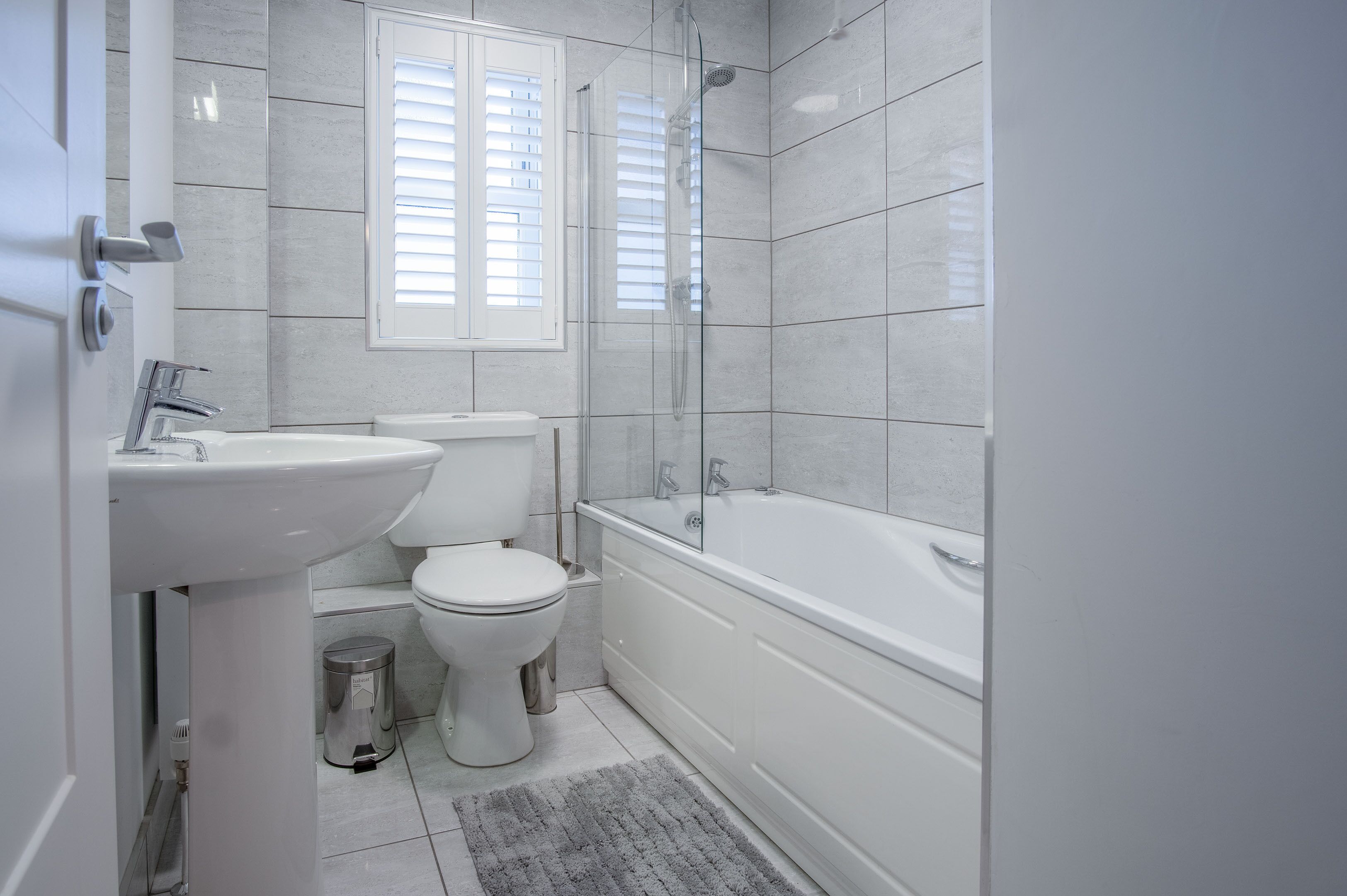 Ein modernes Badezimmer mit Toilette, Waschbecken und Badewanne.