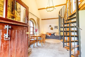 Uma sala de estar espaçosa com escada, móveis de madeira e um lustre.