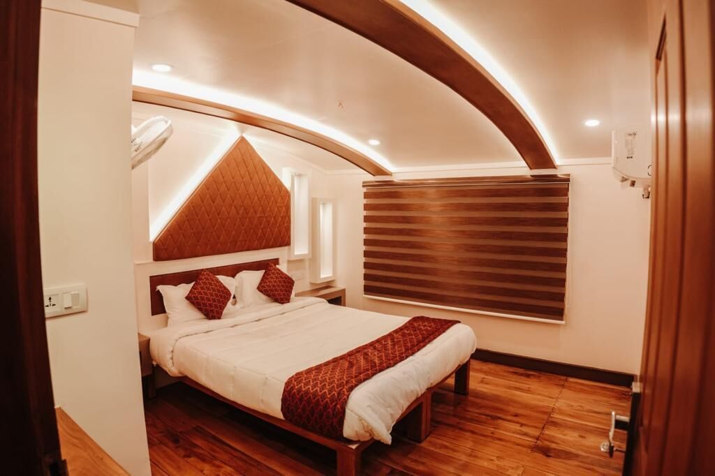 A bedroom with a bed, wooden headboard, and a window with blinds.