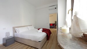 A modern bedroom with a bed, bedside table, and a marble countertop. - 4bnb - Cozy Albornoz Flat (Rome)