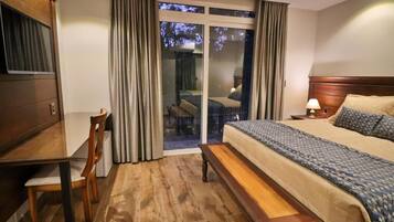 A hotel room with a bed, a desk, and a chair.