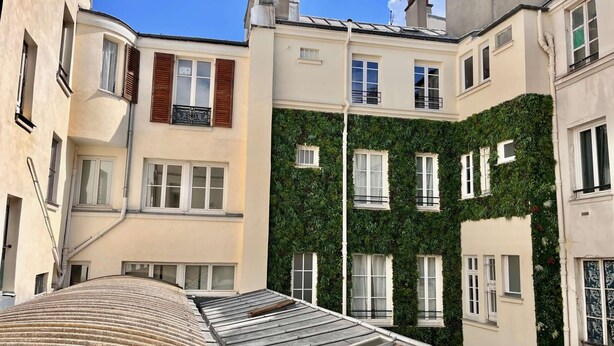 A multi-story building with a flat roof, large windows, and a section covered in greenery. - Center of Paris - Aladdin's house (Paris)