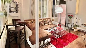 A modern living room with a brown sofa, a glass dining table, and a red rug. - Center of Paris - Aladdin's house (Paris)