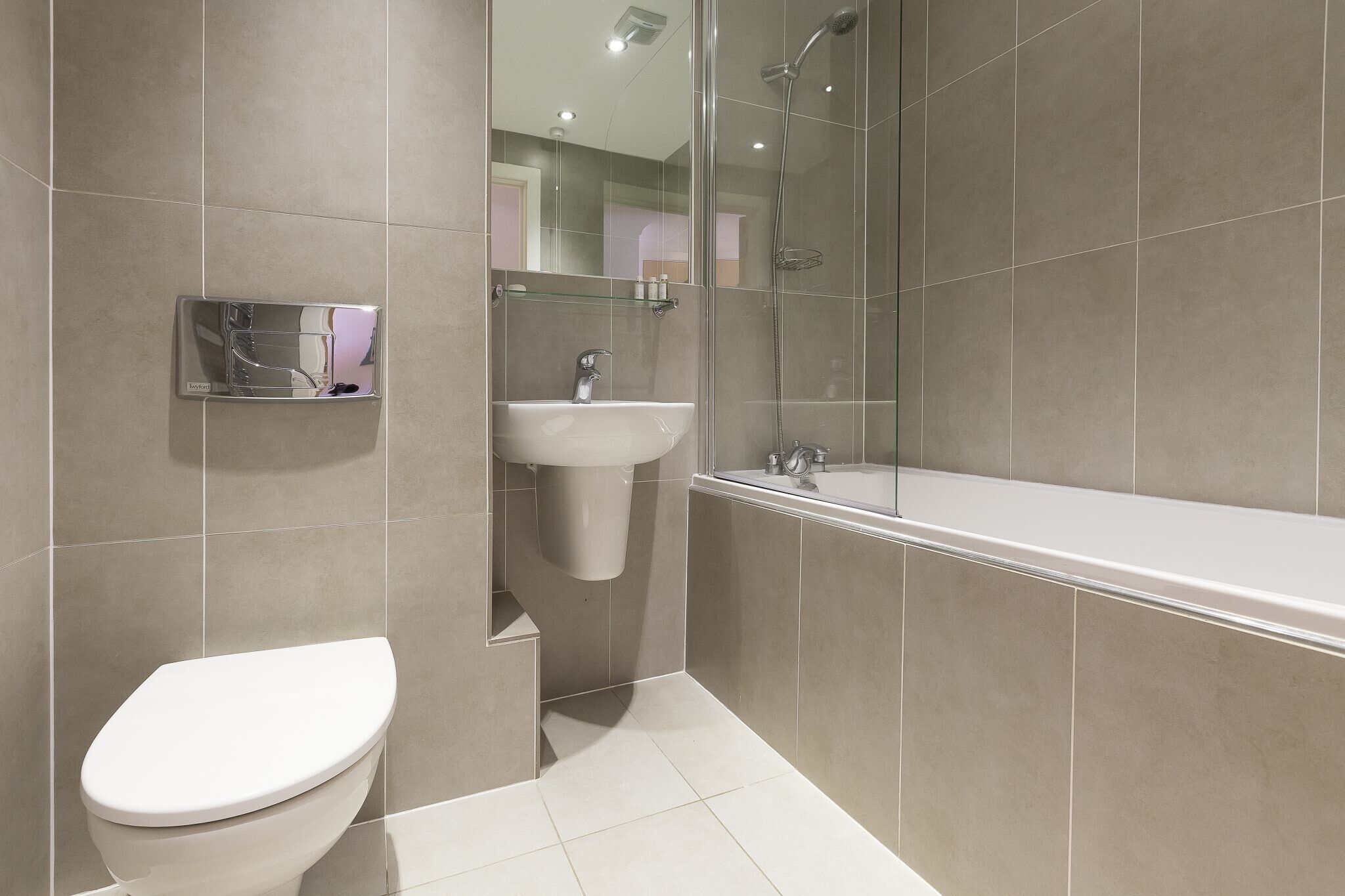 A modern bathroom with a toilet, sink, and shower.