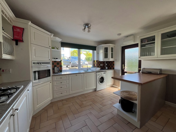Enjoy cooking in this well-equipped kitchen with oven, microwave, and sink, plus a convenient island with additional storage.