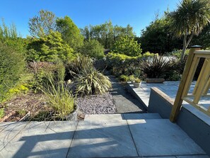 Stroll through the beautifully landscaped garden to a serene outdoor space.