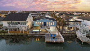 A waterfront property with multiple houses, a dock, and a swimming pool.