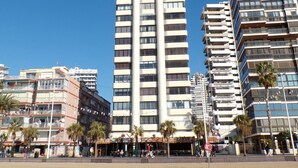 Un edifici alt i modern amb nombroses galeries i un cel blau clar al fons.