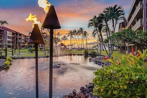 A resort with a pool, palm trees, and a sunset view. - Best Location with Incredible Direct Ocean Views,  A/C Papakea L207 (Lahaina)