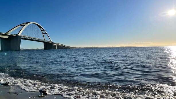 Un pont enjambant une étendue d’eau, avec un ciel dégagé.