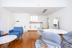 A modern room with a blue sofa, a round table, and grey chairs. - Sprone Apartment in Firenze (Florence)