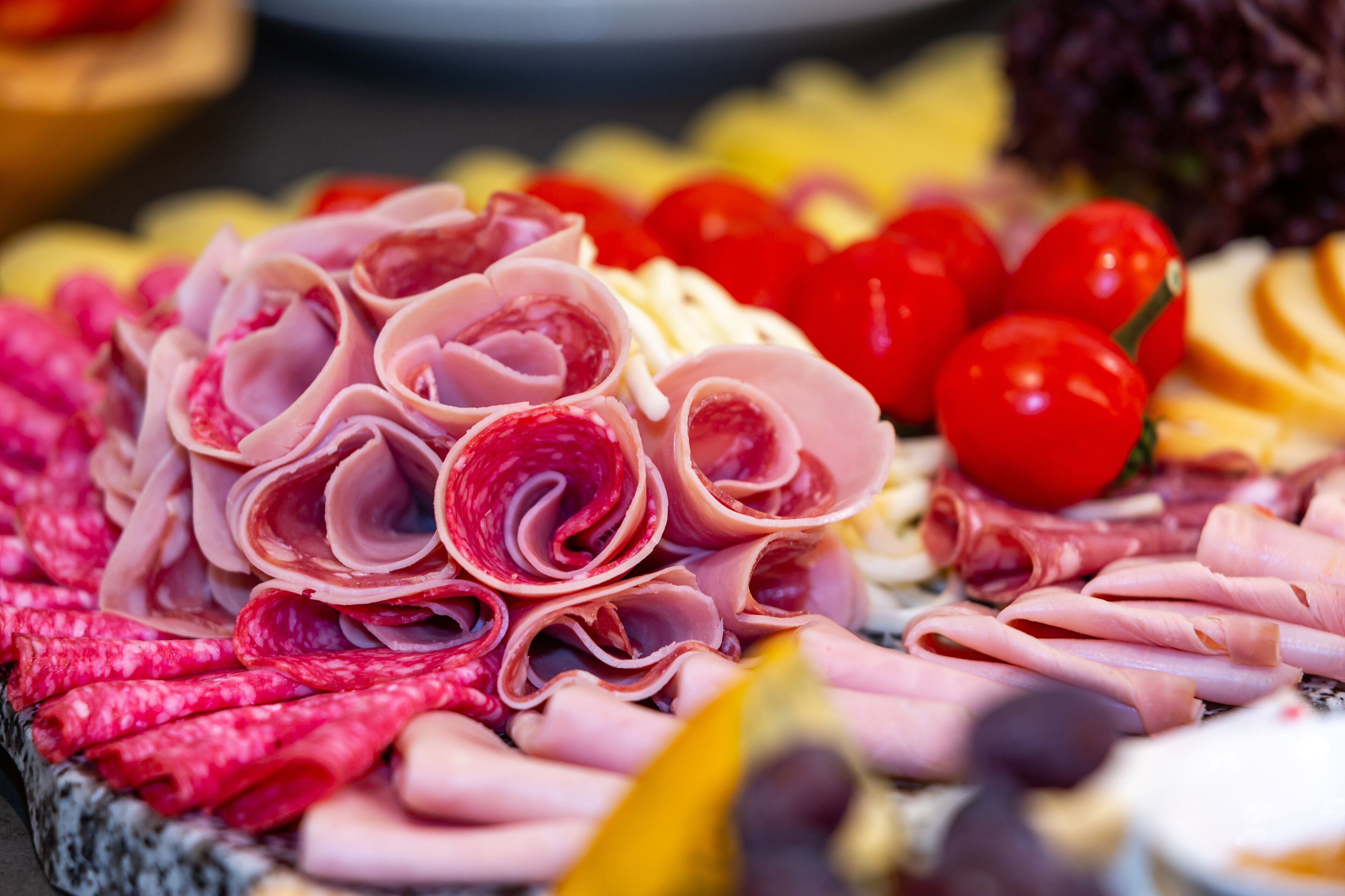 A variety of sliced meats and cheeses arranged on a platter.