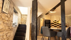 Uma cozinha com painel de parede xadrez, uma ilha central e um espaço de refeições com cadeiras.