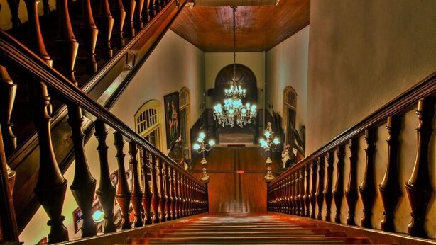 A grand staircase with ornate balusters and a chandelier at the top. - Palace Hotel de Caxambu (Caxambu)