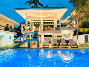 A multi-level building with a pool in front.