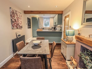 A cozy dining area with a table, chairs, and a view into the kitchen.