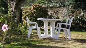 A white plastic table and two chairs in a garden setting. - House with fenced garden in village (Latronquière)