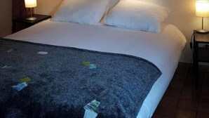 Ein Schlafzimmer mit Holzboden, einem Bett mit weißer Bettwäsche und zwei Nachttischlampen.