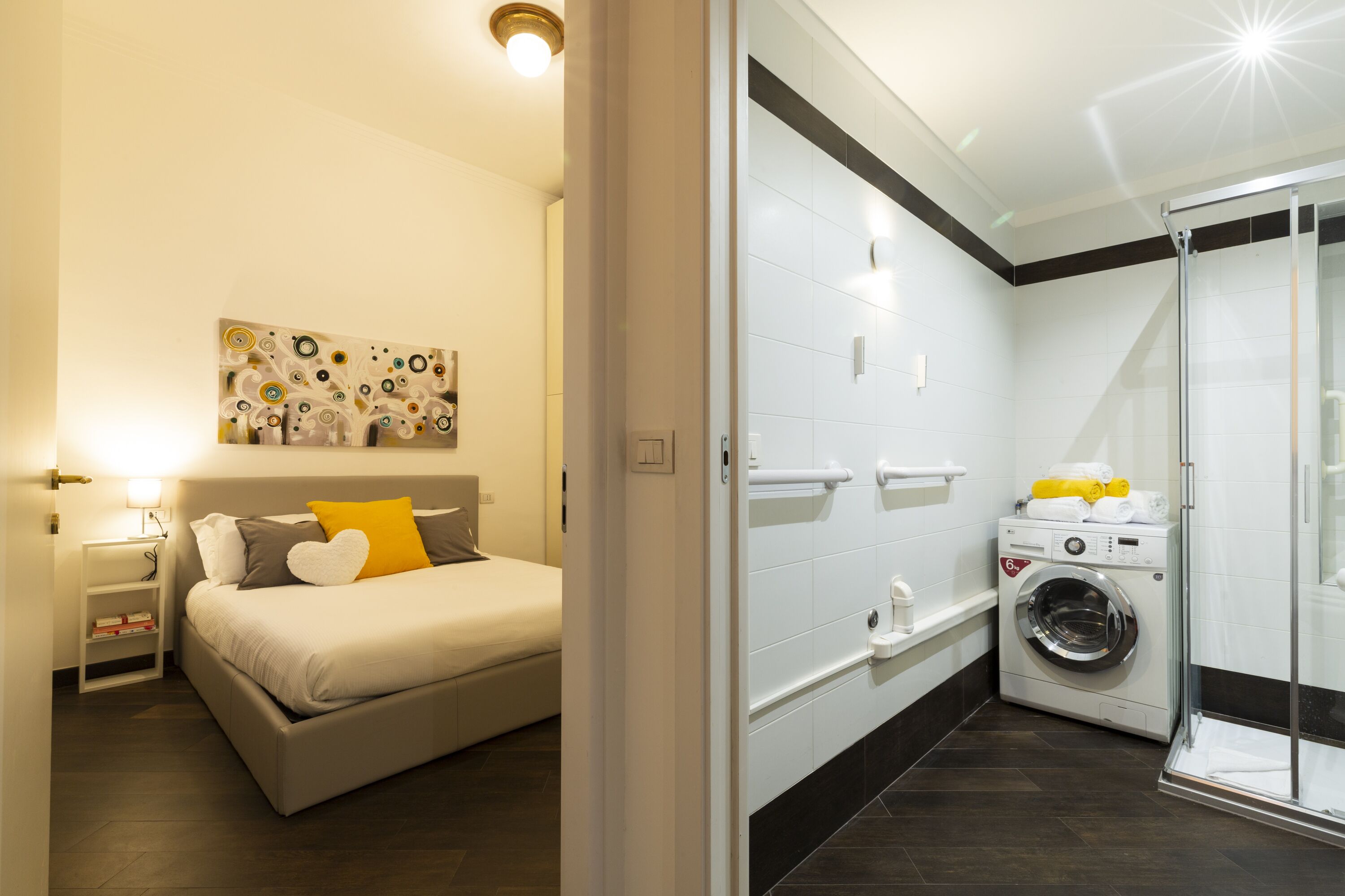 Un dormitorio con cama, mesita de noche y una obra de arte colgada en la pared.