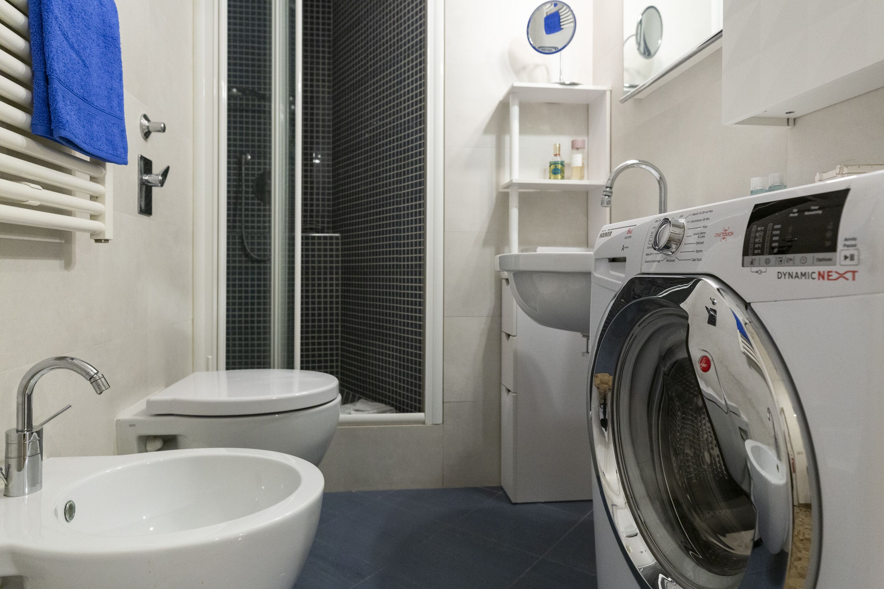 A compact bathroom with a sink, toilet, and washing machine.