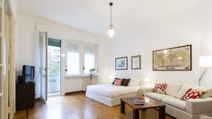 Un salon moderne avec un canapé, une table basse et un téléviseur posé sur un meuble.