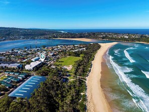 An aerial view of a coastal area with a beach, residential buildings, and a marina. - Golden Sands (Meribula)