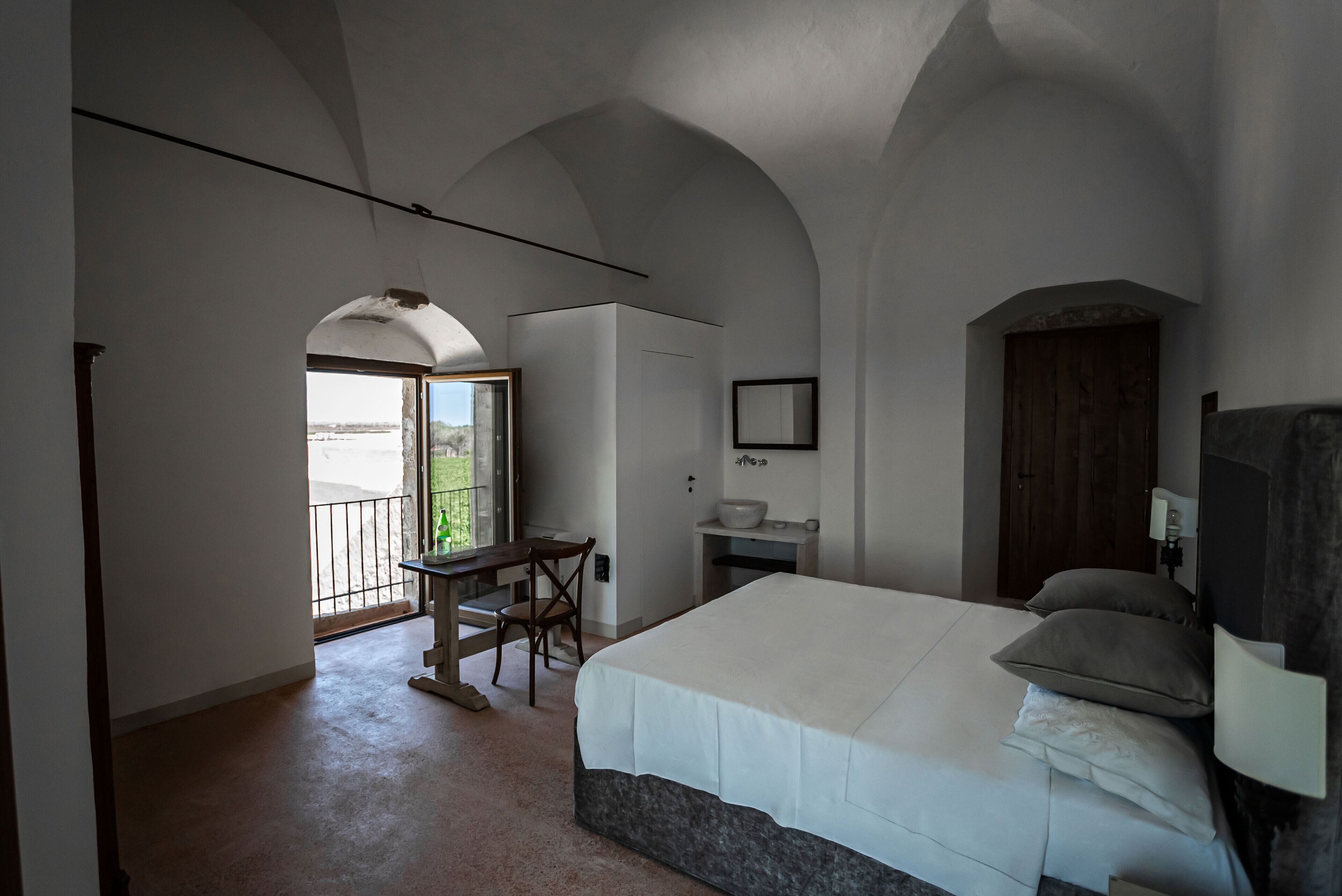 Una camera da letto con un letto grande, una scrivania e vista sull'esterno.