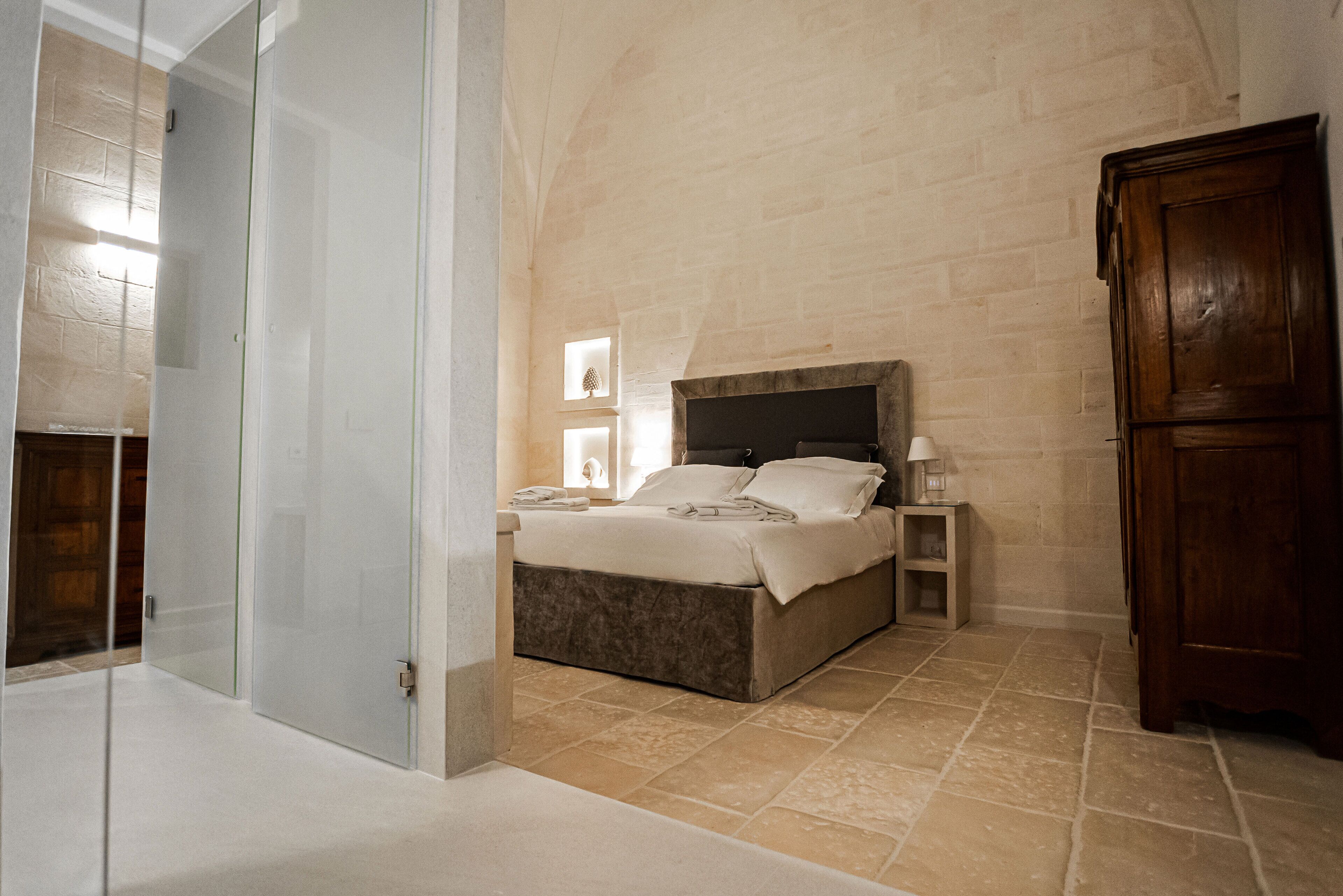 A bedroom with a bed, bedside tables, and a wardrobe.