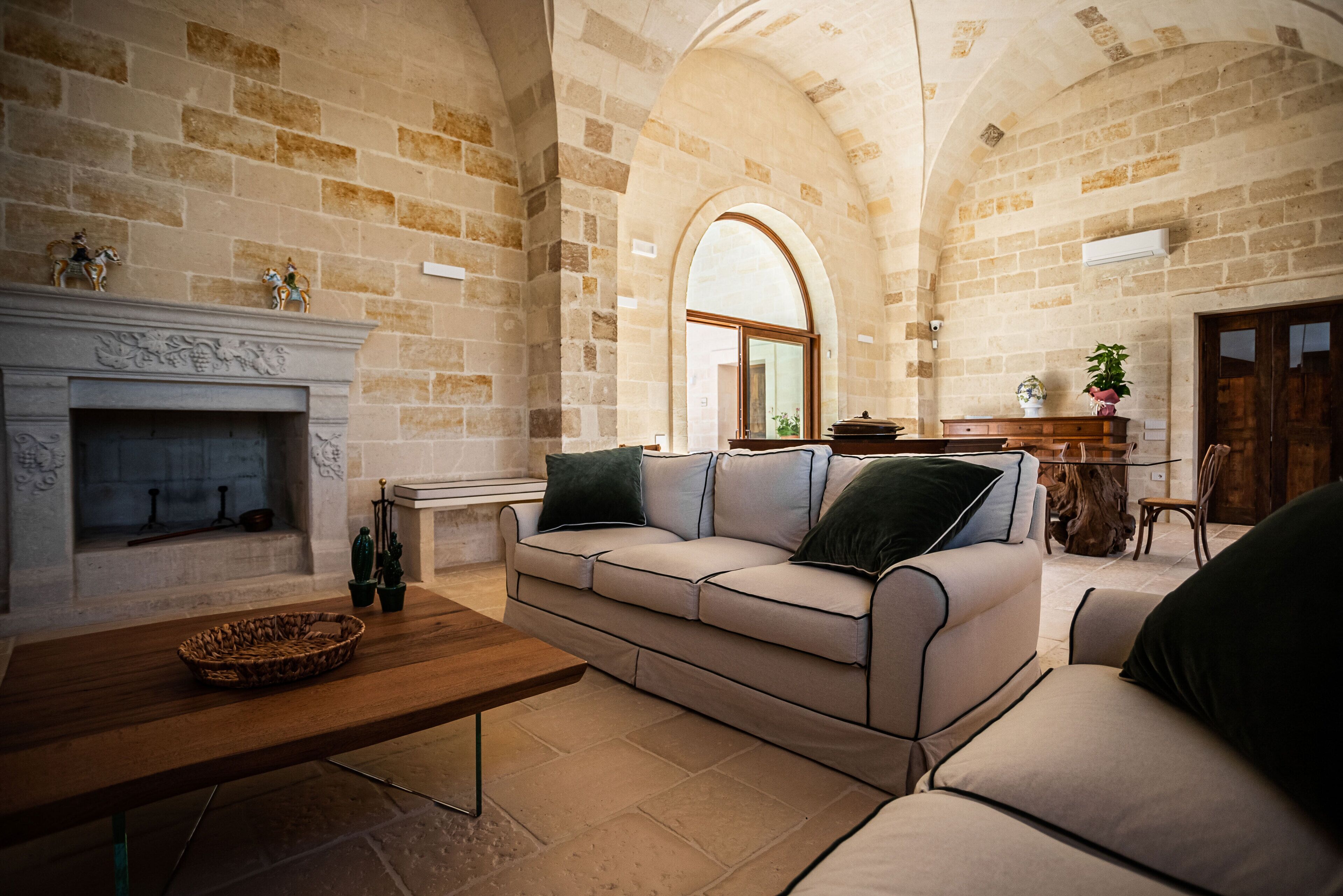 Una sala de estar acogedora con chimenea, un sofá, una mesita de centro y un comedor con mesa y sillas.