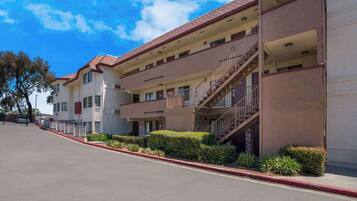 A multi-story hotel with balconies and a red curb.