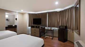 A hotel room with two beds, a desk with a chair, a television, a dresser, and a microwave.
