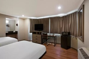 A hotel room with two beds, a desk with a chair, a television, a dresser, and a microwave. - Econo Lodge Vallejo, CA (Vallejo)