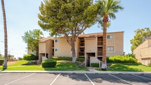 A multi-story building with a parking lot in front. - Condo with Golf Course & Camelback Mountain Views. (Scottsdale)