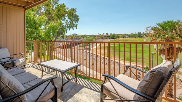 A covered patio with outdoor furniture, a view of a golf course, and a clear blue sky. - Condo with Golf Course & Camelback Mountain Views. (Scottsdale)