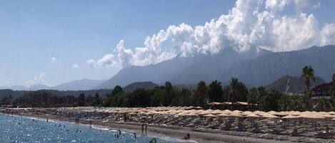 Privatstrand in der Nähe, schwarzer Sandstrand, Liegestühle