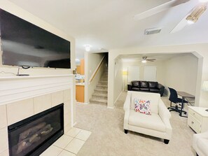 Älytelevisio, takka, kirjoja, tietokoneen näyttö