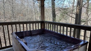 A hot tub on a wooden deck with a view of a forest. - Log Cabin Minutes to Dollywood all Pigeon Forge (Sevier County)