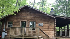 A wooden cabin with a porch, a welcome sign, and a chimney. - Log Cabin Minutes to Dollywood all Pigeon Forge (Sevier County)