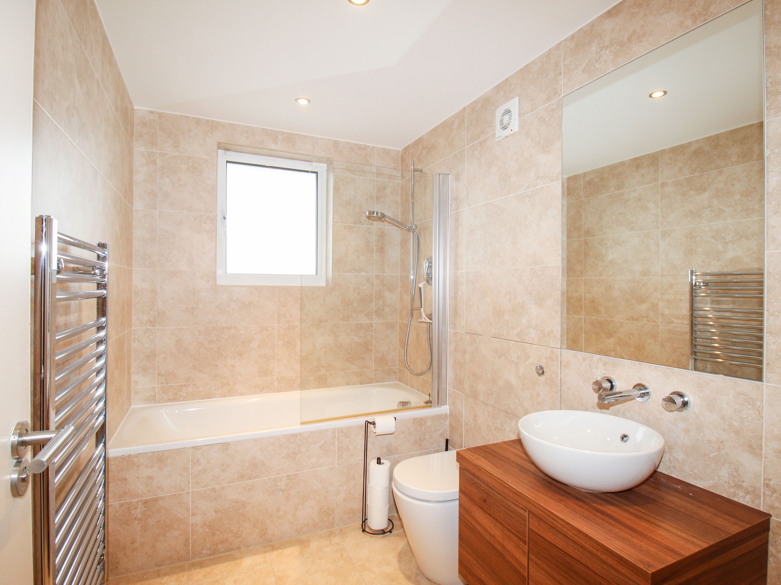 A modern bathroom with a bathtub, toilet, and sink.