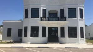 A white building with a central balcony and multiple windows. - Luxury Living at The Harrison (Le Mars)