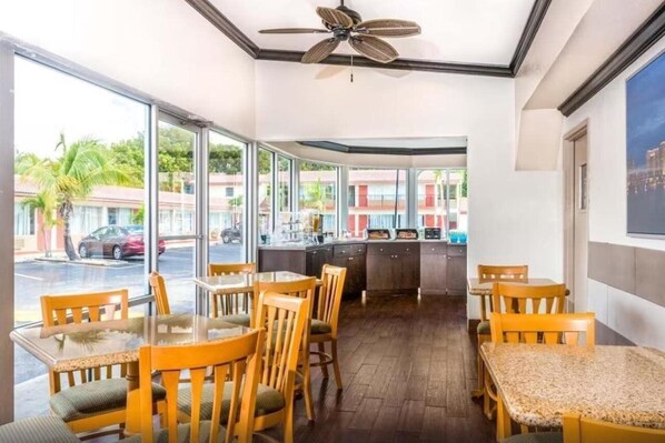 A restaurant with a view of the street, wooden tables and chairs, and a ceiling fan. - Econo Lodge Inn & Suites Florida City (Florida City)
