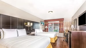 Une chambre d’hôtel avec deux lits, un bureau, une télévision et une fenêtre avec des rideaux.