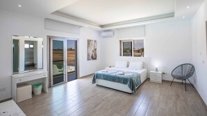 A modern bedroom with a bed, bedside table, and a chair. - Villa Demeter GA98 - Six Bedroom Villa, Sleeps 12 (Paralimni)