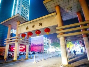 A building entrance with a sign in a foreign language, a red lantern decoration, and a banner with text. - Greentree Inn Anhui Hefei South High-speed Rail Station Fanhua Avenue Haiheng Express Hotel (Hefei)