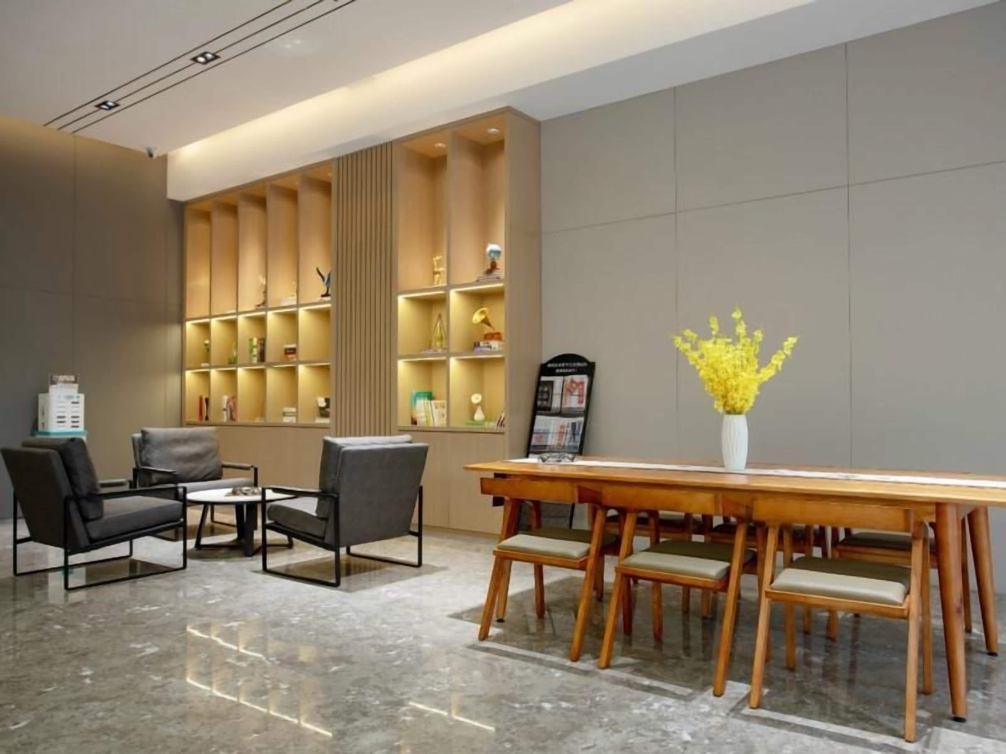 Eine moderne Lobby mit Holzbude, Sitzgelegenheiten und einer Wand mit Regalen.