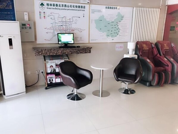 A reception area with a computer monitor displaying a map, a refrigerator, a seating area with chairs, and a massage chair area. - Greentree Inn Beijing Fangshan Yanshan Petrochemical Metro Station Express Hotel (Fangshan)