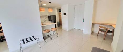 A modern apartment with a kitchen, dining area, and living room.