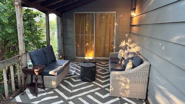 A covered porch with wicker furniture, a patterned rug, and a lantern. - Family Friendly {5 Min To WSU} Spacious (Wichita)