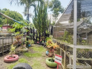 A garden area with a sign reading "TAMAN HIAS" surrounded by potted plants and a fence. - OYO Homes 91148 Homesstay Desa Wisata Bahoi (Bahoi)
